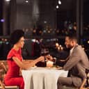 Happy Black Couple Clinking Glasses Drinking Wine And Celebrating Valentine's Day In Restaurant In Evening. Side View