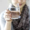 Woman holding up a glass of water