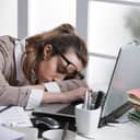 Tired businesswoman sleeping on the desk, in front of the computer screen.