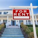 Left Facing For Rent Real Estate Sign In Front of House.