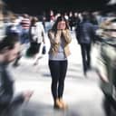 Artistic depiction of a woman standing in a crowd covering her face with hands