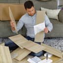 Confused man reading instructions on the floor among a pile of tiles