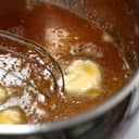 Close-up of a pot while stirring together the ingredients for pie filling.