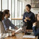 young businesswoman smiling as she leads a corporate meeting in the office