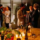People chatting at an networking event while drinking wine.