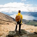 Woman standing on a top of a mountain overlooking Lake Wanaka, New Zealand