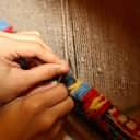 Weaving a carpet on a loom using traditional techniques with wool yarns for warp and weft