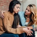 A woman offering comfort to her sad friend.
