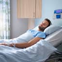 young man lying in a hospital bed connected to an IV drip