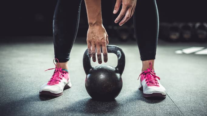 A closeup of a woman lifting a kettlebell