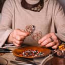 Woman making handmade jewelry out of copper wires and beads