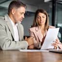 businessman and businesswoman reviewing some papers and discussing about it in a modern office setting