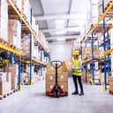 A storage worker placing boxes on the pallet lift