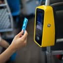 A woman using a ticket machine in a bus