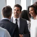 People in business clothes talking with each other at a business party