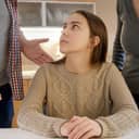 Parents standing over a young girl and lecturing her