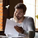 A worried man looking at a piece of paper
