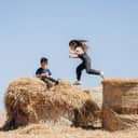 Children playing on hay bales.