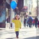 A little girl holding a blue balloon