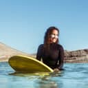Happy girl resting on surfboard in water