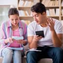 young couple discussing finances while seated on a couch in their living room