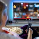 woman relaxing at home and watching TV in the evening