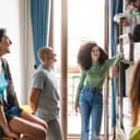 diverse group of young adults enjoying each other's company in a hostel dorm room