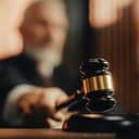 Close-up of a judge's hammer in a courtroom during the trial, blurred background.