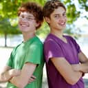 Two young boys leaning against each other's backs