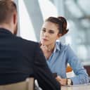 A female manager attentively listening to a male employee during a meeting in the office.