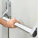 close-up of an emergency door handle and woman pushing it