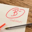 A graded school paper marked in red ink over a wiiden table