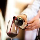A waiter pouring a glass of whine