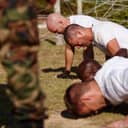 four men at a military boot camp captured doing push-ups together