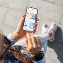 Close-up of a woman scrolling through a social media application on her smartphone.