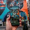 Close-up of smartphone taking a photo of a street art mural 