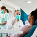 male dentist smiling and talking with a female patient during a dental check-up