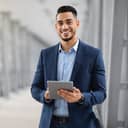 Smiling young businessman holding a tablet
