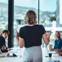 businesswoman presenting strategies to colleagues at a conference meeting in a modern office setting