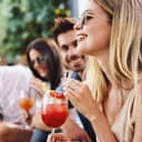 group of friends enjoying cocktails at a sunny daytime summer during bar gathering