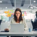 A female worker at an office using a laptop at desk