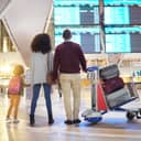 Family looks at flight times on a screen in an airport