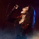 Young woman emotionally singing into a microphone