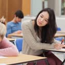 Student cheating on the exam by looking at another student's work