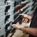 man holding a handgun in a gun shop