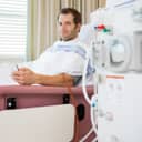 A patient connected to a dialysis machine lying in hospital bed 
