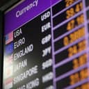 Close-up of a digital display board showing the latest currency exchange rates.