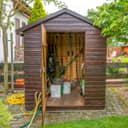 An open garden shed with tools inside