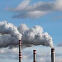 Thick smoke coming out of three industrial chimneys