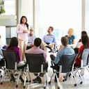 Businesswoman speaking to a multi-cultural staff during an office meeting